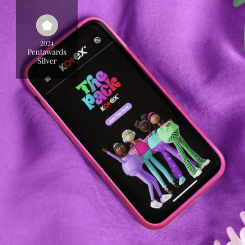 A phone showing the Kotex: The Pack website landing page, on a bed