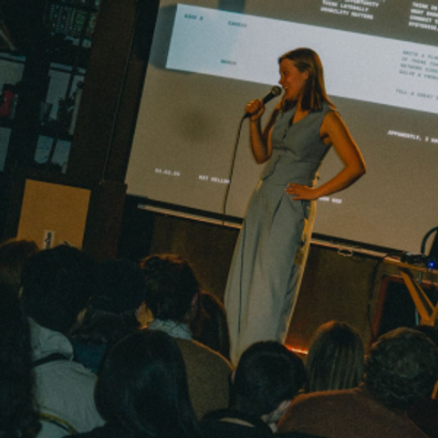 Kat Mellor holding a microphone, speaking at a Process Events event in London