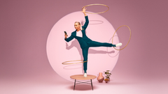 Woman performing three hula hoops whilst standing on a table whilst signing contracts using Oneflow on her phone